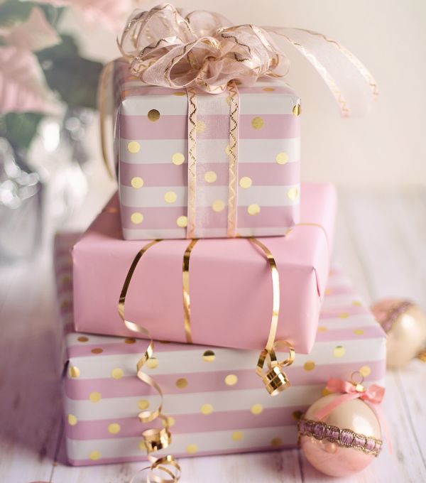Pink wrapped gift boxes with gold ribbons